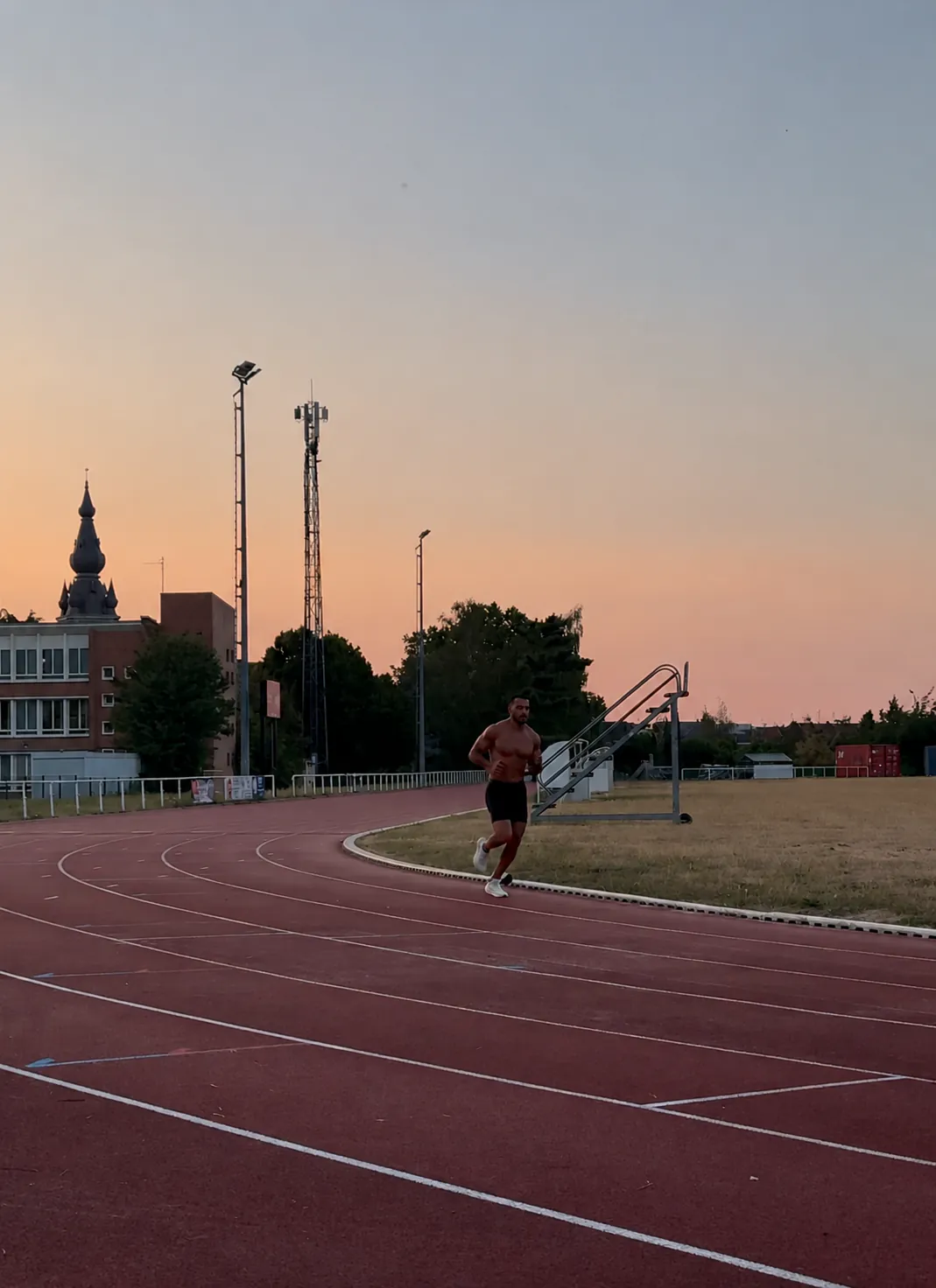 Le coach court sur une piste d’athlétisme au coucher du soleil